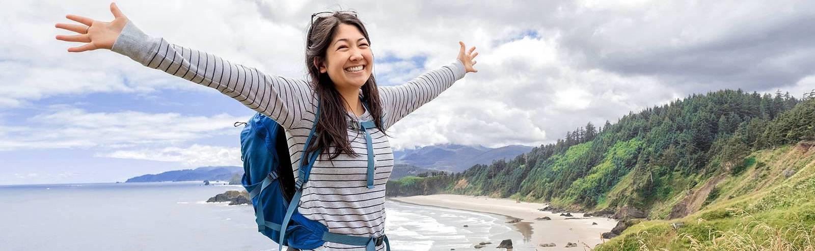 Photo of hiker celebrating by the beach