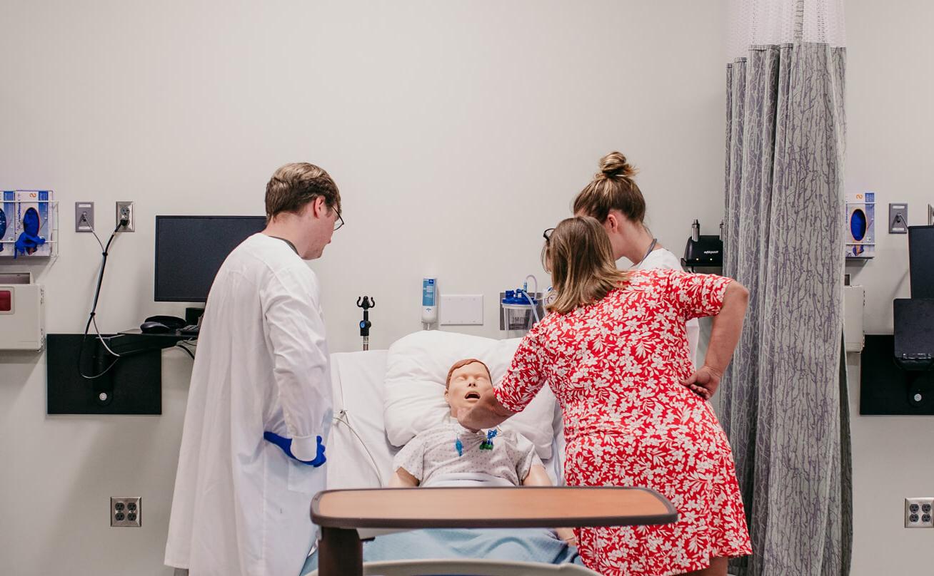 Photo of students with a medical mannequin